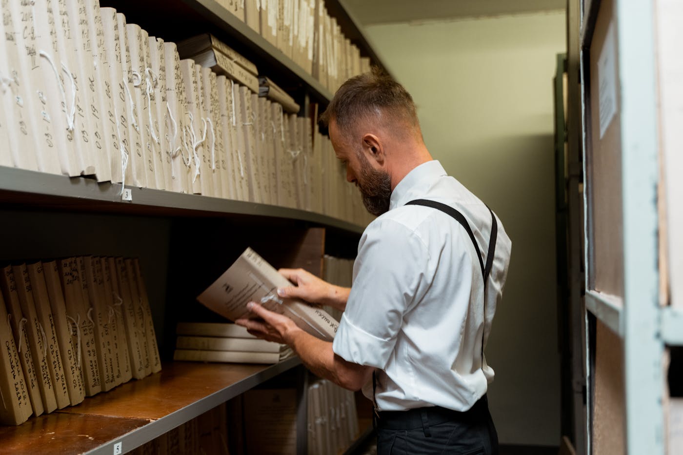 Researcher reviewing handwritten property records in an archive.
